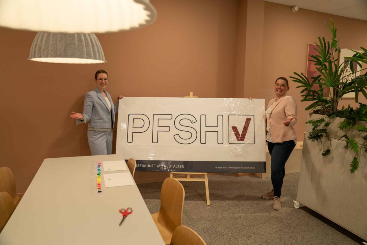 Zwei Frauen präsentieren das PFSH-Logo bei der Eröffnungsfeier.