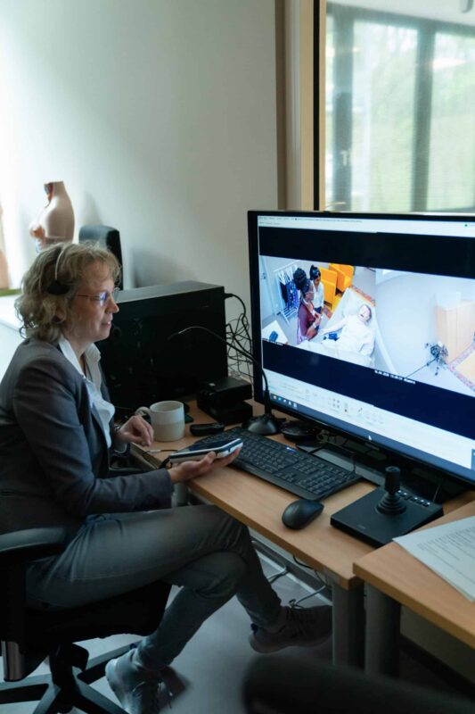 Frau arbeitet an Computer mit Pflegebildern für Ausbildung.